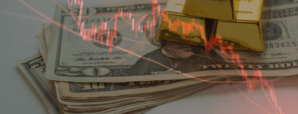 A stack of U.S. dollars, with a $5 bill, $10 bill, and $20 bill sticking out, and a stack of 3 gold bars on top, all behind a red plot graph decreasing in value.