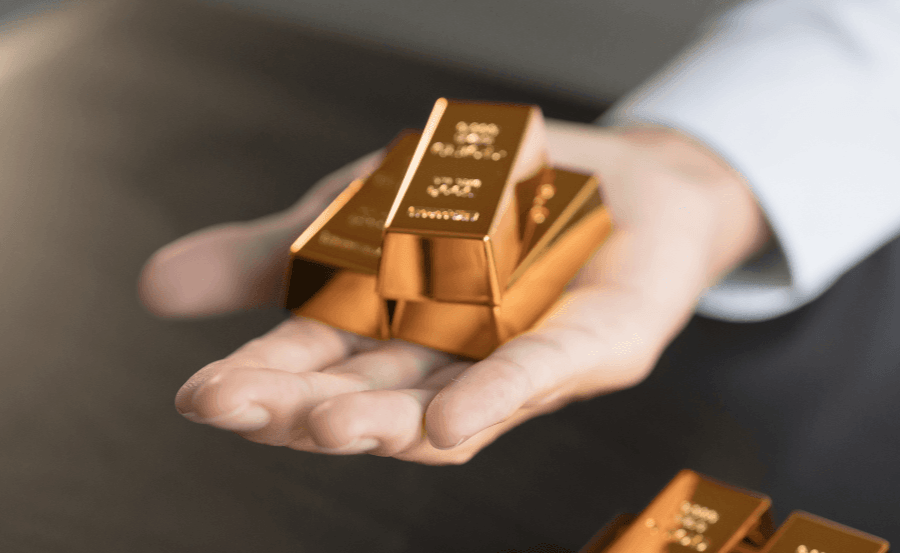 Outstretched hand offering a stack of 3 gold bars.